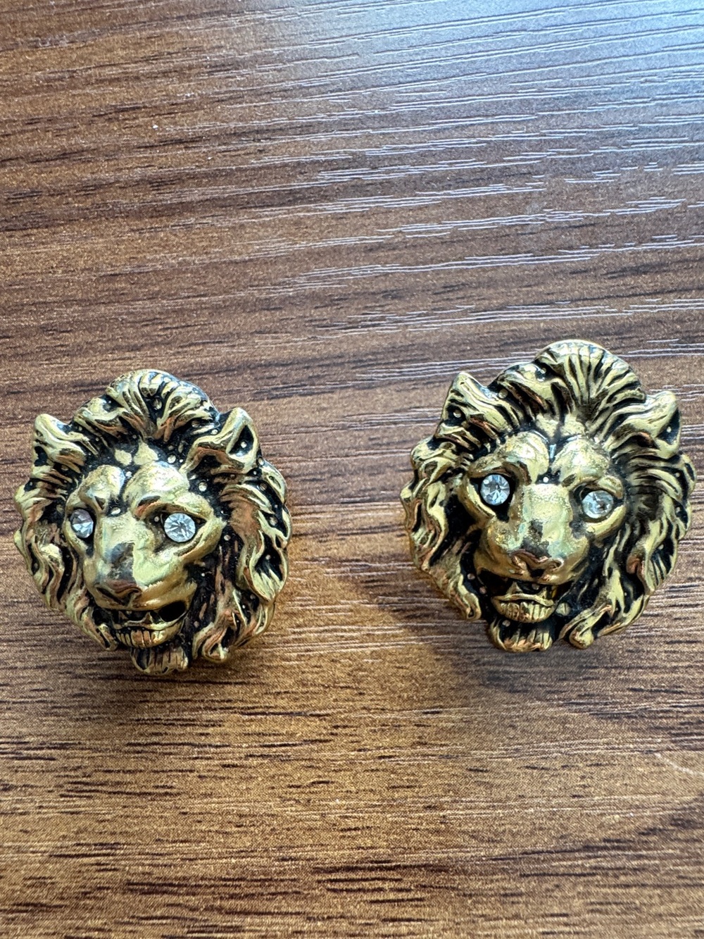 Vintage gold-tone lion head earrings with crystal eyes